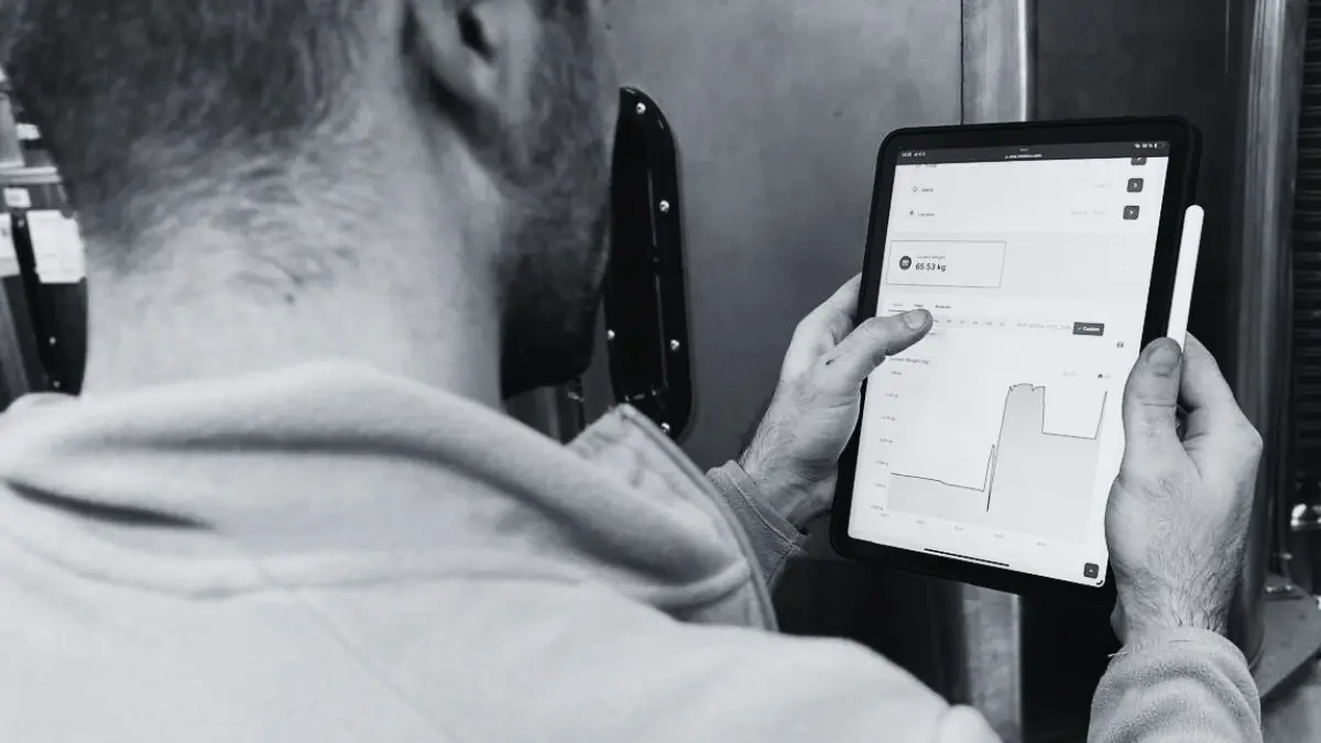 worker looking at tablet with Heliotics platform on